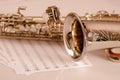 Closeup partly view of shiny saxophone lying on musical notes paper Royalty Free Stock Photo