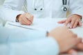 Close-up image of patients hands and doctor taking notes. Ward round, patient visit check, medical calculation and Royalty Free Stock Photo