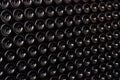 Closeup pattern from bottom of old dark dusty wine bottles in rows in cellar, basement, wine warehouse, winery. Concept