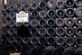 Closeup pattern from bottom of old dark dusty wine bottles in rows in cellar, basement, wine warehouse, winery. Concept Royalty Free Stock Photo