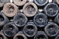 Closeup pattern from bottom of old dark dusty wine bottles in rows in cellar, basement, wine warehouse, winery. Concept Royalty Free Stock Photo