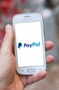 Closeup of paypal logo on smartphone screen in hand from Samsung brand in the street Royalty Free Stock Photo