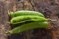 Closeup of pea pods on a wooden table wet with water drops Royalty Free Stock Photo