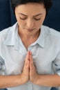 Closeup of peaceful millennial woman meditating, mental health. Woman holding hands in namaste gesture meditate, mental