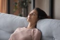 Closeup peaceful woman fall asleep leaned on comfy sofa cushion