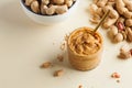 Closeup peanut butter in a glass jar, a handful of peanuts in shell. Foodphoto. Copy space. Breakfast for vegetarians