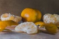 Closeup of peeled and whole tangerines on a table with a blurry background