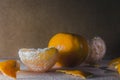 Closeup of peeled and whole tangerines on a table with a blurry background