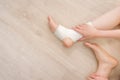 Closeup People of a Foot with White Gauze Elastic Bandage. Hands on Injured Legs and Feet on Pain Area. Asian Young Woman Ankle Royalty Free Stock Photo