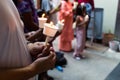 Closeup of people holding candle vigil in dark seeking hope