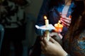 Closeup of people holding candle vigil in dark seeking hope