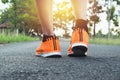 Closeup people walking with orange shoes on road in park for health concept. Royalty Free Stock Photo