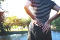 Closeup hands of woman touching her back pain in healthy concept on nature background. Royalty Free Stock Photo