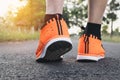 Closeup people walking with orange shoes on road in park for health concept. Royalty Free Stock Photo