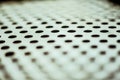 Closeup perforated aluminium sheet of metal texture. Old surface with depth of field, abstract industrial mesh Royalty Free Stock Photo