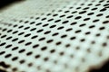 Closeup perforated aluminium sheet of metal texture. Surface with depth of field, abstract industrial mesh background Royalty Free Stock Photo