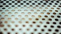 Closeup perforated aluminium sheet of metal texture. Surface with depth of field, industrial mesh background Royalty Free Stock Photo