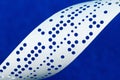 Closeup of perforated punched tape on blue background Royalty Free Stock Photo