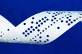 Closeup of perforated punched tape on blue background Royalty Free Stock Photo