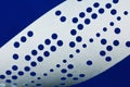Closeup of perforated punched tape on blue background Royalty Free Stock Photo