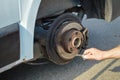 Closeup of person changing vehicle tire with bare hands. Outdoors background Royalty Free Stock Photo