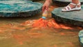 closeup person feeds fish in lake from planked footways in park