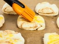 Closeup of person glazing plaited swirl buns