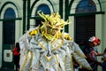 Closeup person in golden demon costume poses for photo at dominican carnival