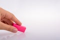 Closeup of a person holding a pink eraser isolated on a white background Royalty Free Stock Photo