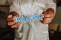 Closeup of a person holding a wedding bride garter under the lights with a blurry background