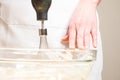 Closeup of a person mixing batter for cheesecake in a bowl on the table