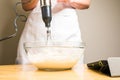 Closeup of a person mixing batter for cheesecake in a bowl on the table