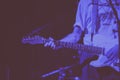 Closeup of a person playing white electric guitar in a pub covered with blue lights Royalty Free Stock Photo