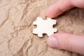 Closeup of a person putting a puzzle piece on a parchment paper under the lights