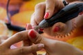 Closeup of a person removing shellac with a machine