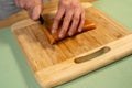 Closeup of a person slicing fish for sushi on a wooden board on the table Royalty Free Stock Photo