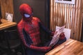 Closeup of a person in the Spider-Man costume looking at the menu in the cafe. Fort Worth, Texas.