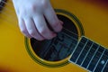 Closeup of a person strumming a guitar with their hands close to the strings Royalty Free Stock Photo