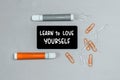 Closeup of a personal agenda with words - Learn to love yourself - written on a business card with a felt-tip pen Royalty Free Stock Photo