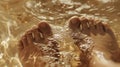 A closeup of a persons feet submerged in a warm foot bath filled with essential oils known for their detoxifying and