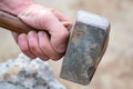 closeup of a persons hand gripping a hammer handle