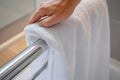 closeup of a persons hand placing a towel on a rail