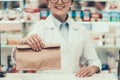 Closeup Pharmacist Holding Brown Bag with Medicine