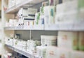 Closeup, pharmacy and medicine with healthcare, pills and shelf with boxes, bottles and treatment. Zoom, medication and