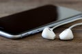 Closeup phone and earbud on wood