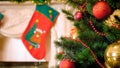 Closeup image of adorned Christmas tree against decorated mantelpiece with hanging stockings for gifts Royalty Free Stock Photo