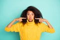 Closeup photo of amazing playful dark skin curly lady holding fingers near cheeks hold breath wear yellow knitted jumper
