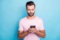 Closeup photo of attractive guy holding telephone hands blogger writing new comments modern person wear casual pink t Royalty Free Stock Photo