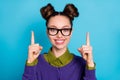 Closeup photo of attractive pretty student lady two funny buns direct fingers up empty space showing novelty wear specs