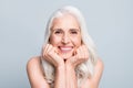 Closeup photo of beautiful aged woman beaming toothy smile touch arms cheekbones isolated grey color background Royalty Free Stock Photo